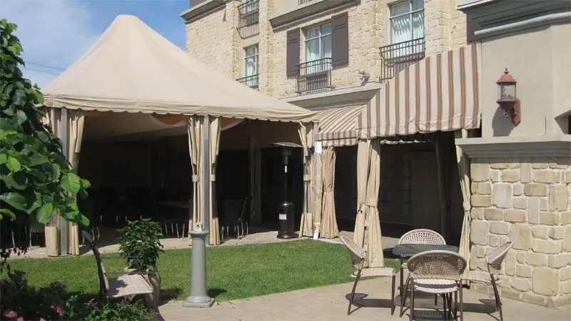 Marquise et auvents rayés au-dessus d'une terrasse de restaurant